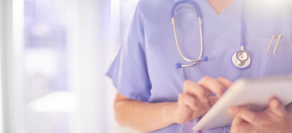 Eine Krankenschwester hält ein Tablet in der Hand