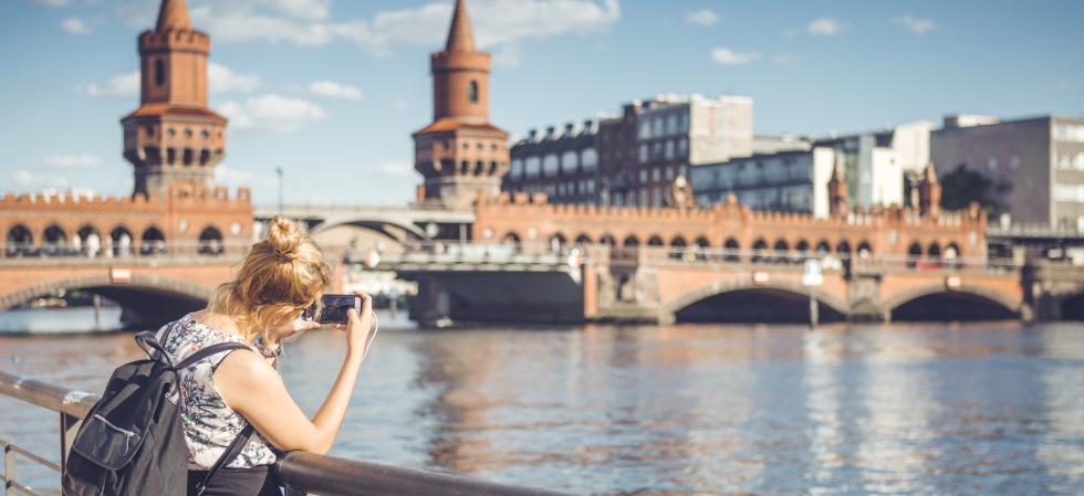 Женщина фотографирует в Oberbaumbrücke в Берлине