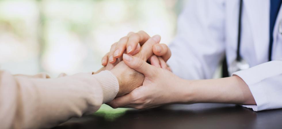 Arzt hält die Hand des Patienten