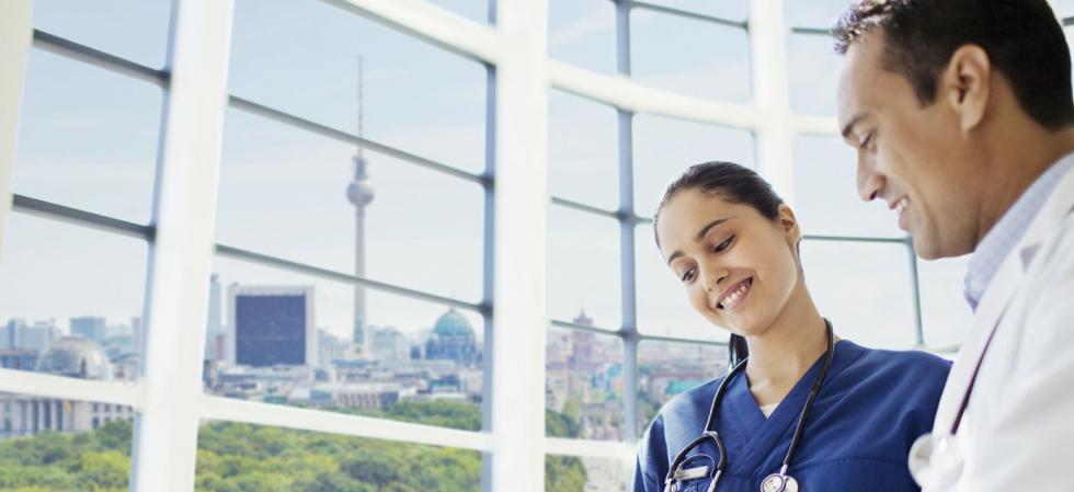 Krankenschwester und Arzt im Gespräch mit Berliner Fernsehturm im Hintergrund